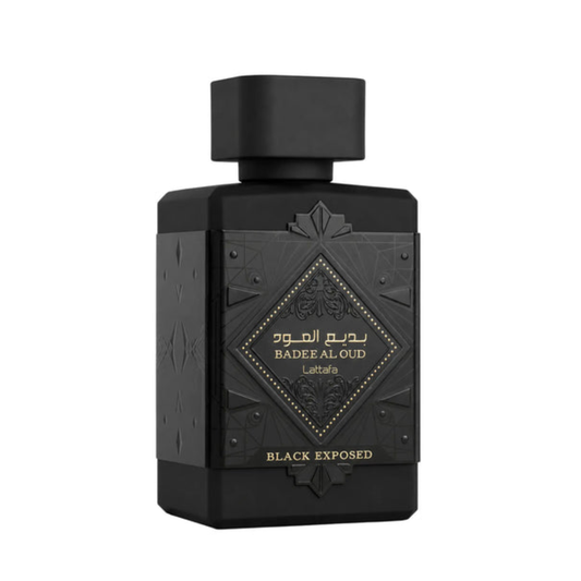 A matte black rectangular perfume bottle with a matching black cap, featuring an embossed geometric design and a central diamond-shaped gold label that reads 'BADEE AL-OUD' and 'La Zafara'.